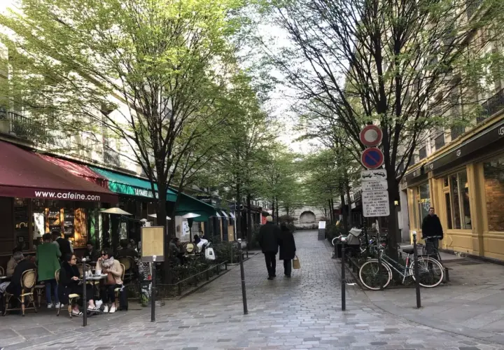 Spacerem w paryskiej dzielnicy Le Marais, z kawiarniami i sklepami po bokach, wczesną wiosną.