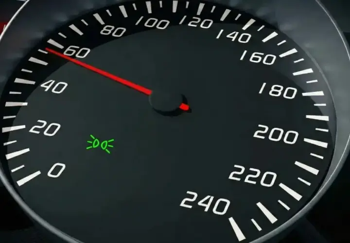 Cruscotto auto: tachimetro segna 60, spia luci posizione accesa.