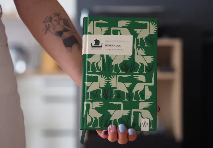 Zielona okładka książki "Mokradła" Marii Turtshaninoff, z ptakami i roślinami, symbolizuje mrok i naturę, przyczyny sukcesu literatury skandynawskiej w Polsce.