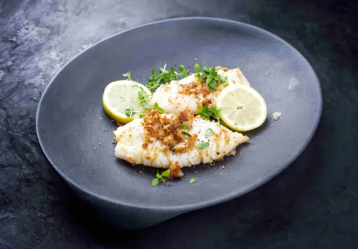 Calamares a la plancha con limón, cubiertos de pan rallado crujiente y hierbas frescas. Un plato ligero y sabroso.