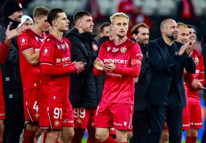 Piłkarze w czerwonych strojach, z numerami 14, 91, 99, 4, 6, klaszczą. Czy Widzew jest w Ekstraklasie?