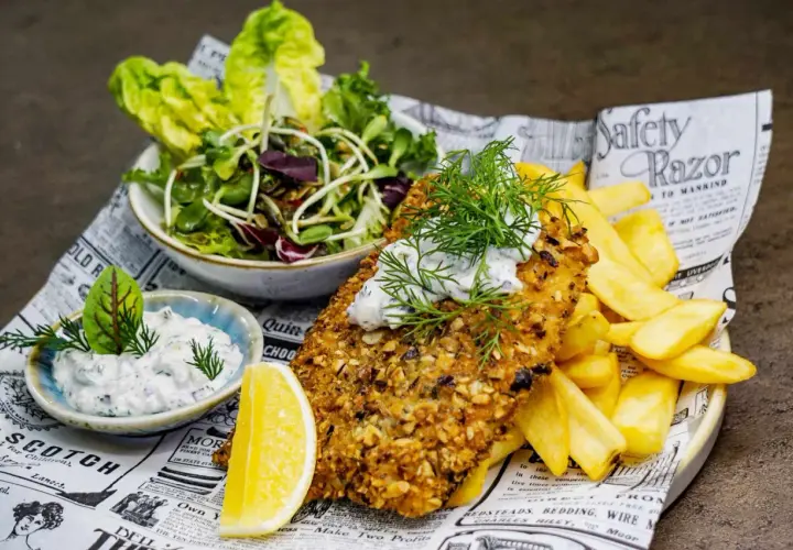 Ryba w panierce z orzechów, frytki, sałatka i sos – idealne danie, które mogłoby znaleźć się w rankingu 10 najlepszych restauracji w Kielcach.