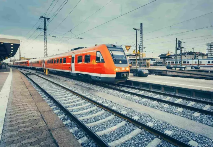 Pomarańczowy pociąg na stacji, gotowy do podróży. Jastarnia Hel odległość to tylko kilka godzin pociągiem.