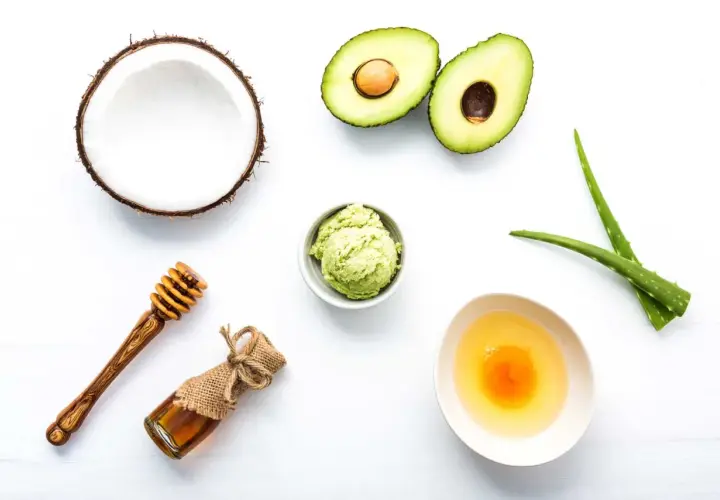 Ingredientes para una mascarilla casera para el pelo: aguacate, coco, aloe vera, miel y huevo.
