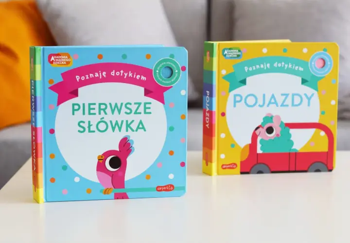 Dwie książeczki z serii Akademia Mądrego Dziecka: "Pierwsze słówka" z ptaszkiem i "Pojazdy" z uroczym stworkiem w czerwonym aucie.
