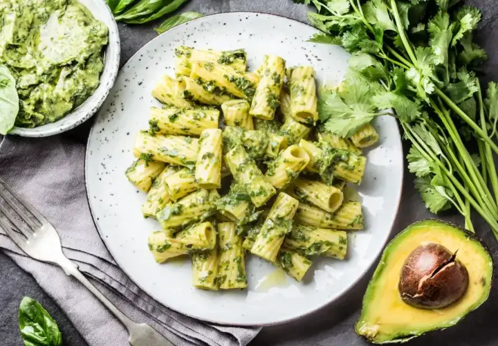 Makaron rigatoni z kremowym pesto zielonym, świeżą kolendrą i awokado. Pyszne danie z aromatycznym pesto zielonym.