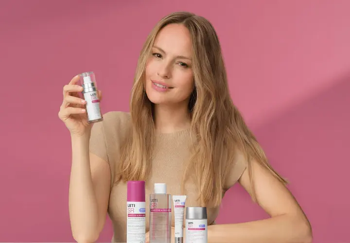 Mujer sonriente con productos Leti SR, ideales para el cuidado de la piel sensible.