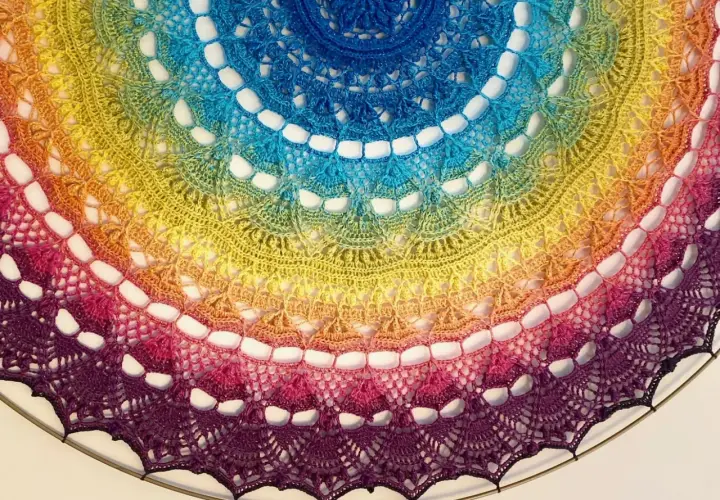 Kolorowa, tęczowa mandala z koronki, niczym tatuaż mandala między piersiami, ozdobiona misternym wzorem.