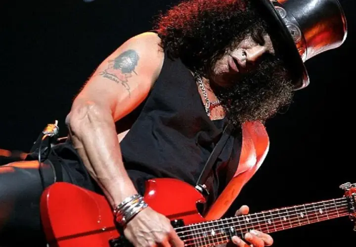 Slash w cylindrze gra na czerwonej gitarze, jakby śpiewał "sweet child o' mine".