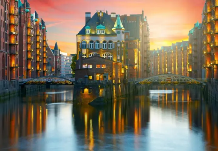 Vackra tegelbyggnader längs en kanal i Hamburg vid solnedgången. Perfekt för en weekend i Hamburg.