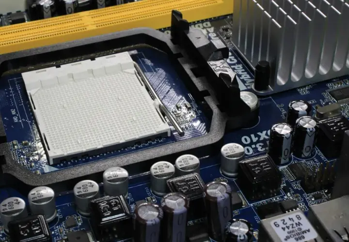 Placa base azul con zócalo de CPU, ranuras de memoria amarillas y disipador plateado. Ideal para saber que placa base tengo.