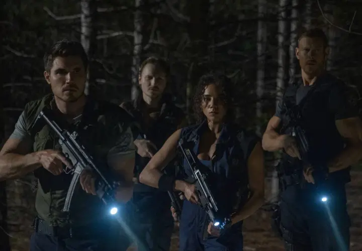 Quattro personaggi armati e con torce si muovono cauti nel bosco, pronti ad affrontare pericoli. Resident Evil: Welcome to Raccoon City recensioni.