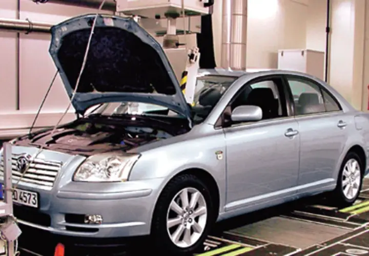 Srebrna Toyota Avensis 2.0 D4D z otwartą maską stoi na stanowisku diagnostycznym.