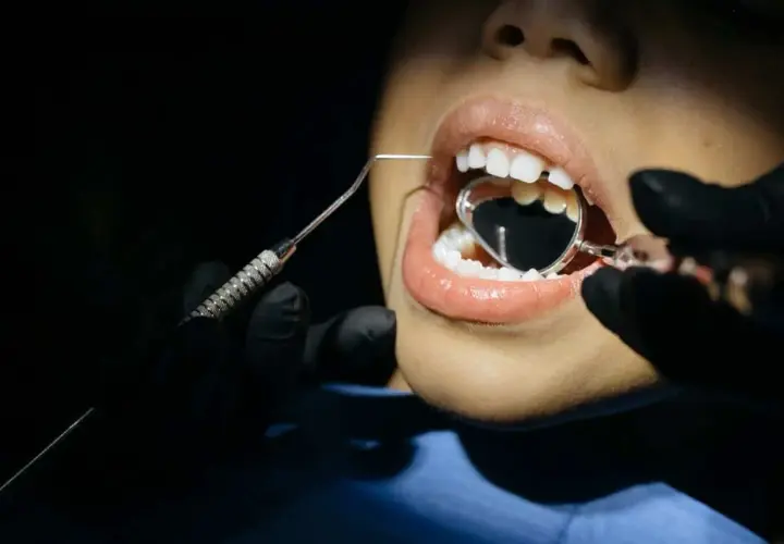 Boca abierta con espejo dental y explorador. ¿Se me rompen las muelas? Significa que es hora de visitar al dentista.