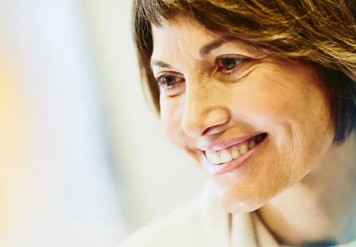 Sorriso di un'infermiera libera professionista che pensa al calcolo stipendio netto.