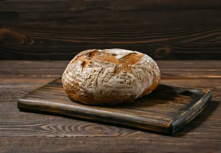 Chleb bezglutenowy na drewnianej desce. Dowiedz się, jak upiec chleb bezglutenowy, by był pyszny i puszysty.