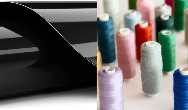 Rouleau de vinyle noir brillant pour flocage textile, à côté de bobines de fil colorées.