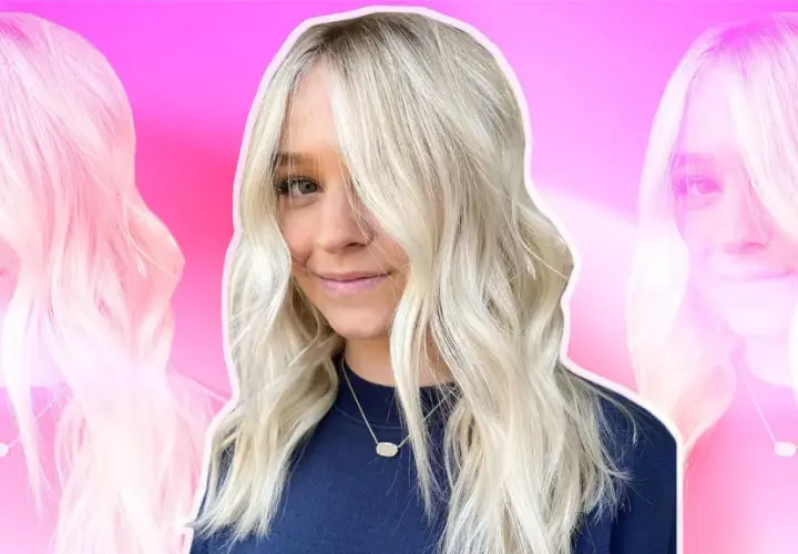 Mujer sonriente con cabello rubio platino, peinado en ondas suaves. Las mechas platinadas resaltan su rostro.