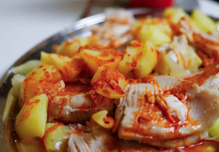 Raya a la gallega, un plato tradicional con trozos de pescado blanco y patatas cocidas, espolvoreado con pimentón.