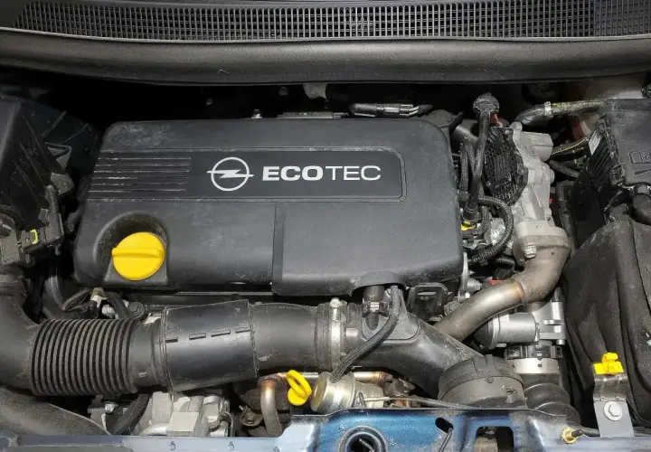 Silnik Ecotec w Opel Meriva 1.7 CDTI. Widoczny czarny plastikowy dekiel z logo Opla i napisem Ecotec, żółty korek oleju, przewody i elementy układu dolotowego.