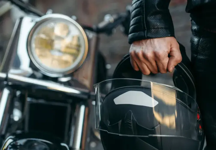 Motociclista con casco negro, listo para aprender como dar de baja una moto.