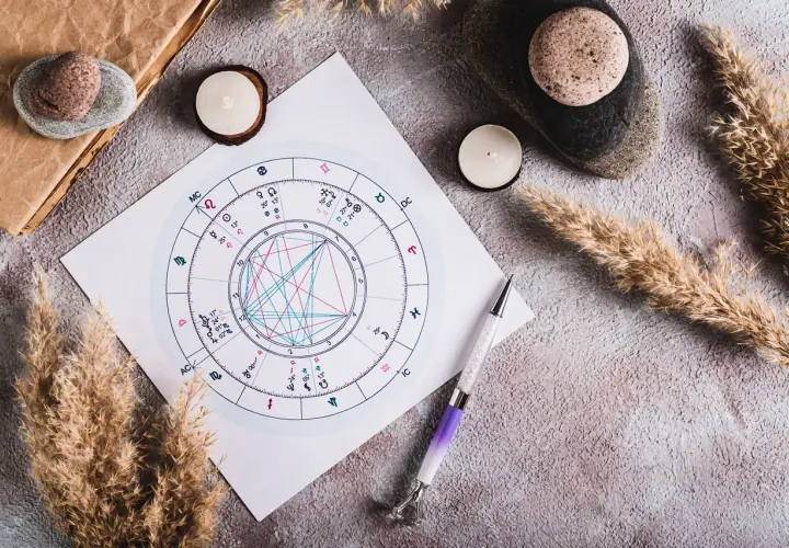 Astrologiczna mapa nieba, świece i pióro. Jak obliczyć ascendent bez godziny urodzenia?
