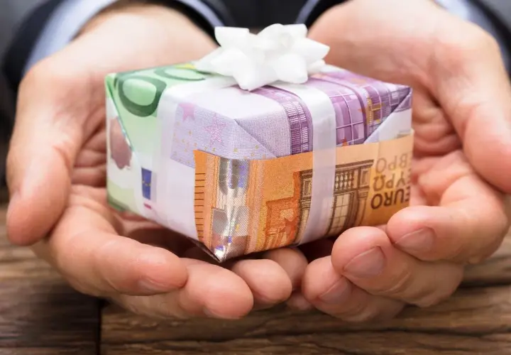 Oto jak śmiesznie zapakować pieniądze na prezent: banknoty euro tworzą małe pudełko przewiązane białą wstążką.