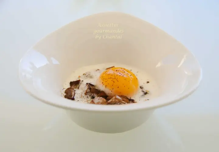 Un œuf parfait, onctueux et doré, baignant dans une sauce crémeuse avec des éclats de champignons. Un délice pour les yeux et les papilles.