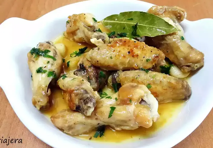 Alitas de pollo al ajillo, doradas y jugosas, bañadas en una salsa aromática con ajo y perejil fresco. Un plato delicioso.