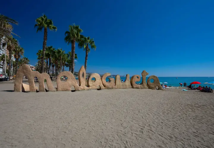 Piaskowy napis "Malagueta" na plaży, palmy i błękitne morze. Czy Malaga ma dostęp do morza? Tak, jak widać!