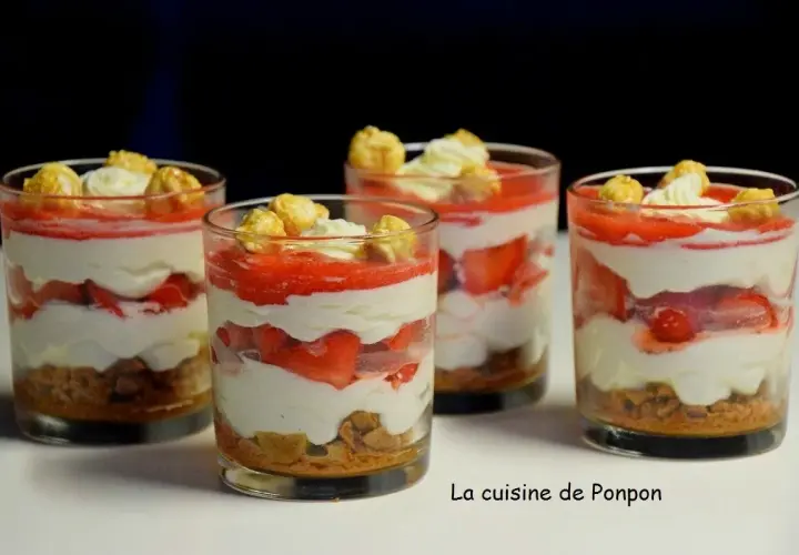 Quatre verrines fraise mascarpone superposant biscuits émiettés, crème onctueuse, fraises fraîches et coulis, surmontées de chantilly et de pop-corn caramélisé.