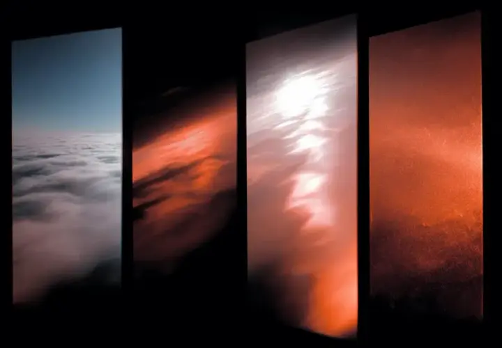Quattro pannelli verticali mostrano un cielo che sfuma dal blu al giallo e rosso, con nuvole che cambiano colore.
