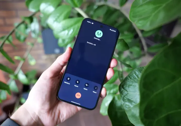 Dłoń trzyma smartfon z ekranem rozmowy. Widoczny jest komunikat "Dzwonię..." oraz numer komórkowy +48.