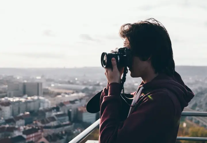 Młody mężczyzna, którego pasją jest fotograficzny zawód, uchwycił panoramę miasta.