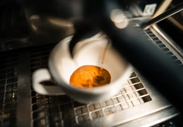 Frisch gebrühter Espresso fließt in eine weiße Tasse. Manche sagen, entkoffeinierter Kaffee sei krebserregend, aber dieser hier sieht köstlich aus.