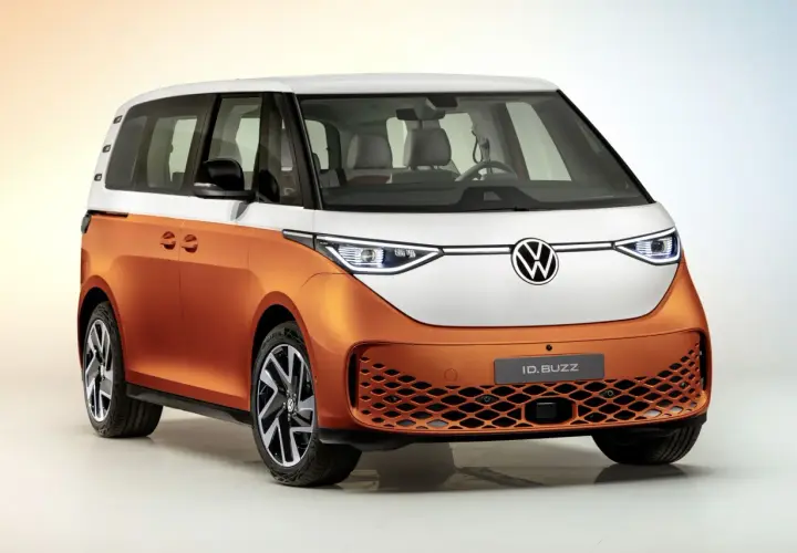 Il Volkswagen ID. Buzz, un furgone elettrico bicolore arancione e bianco, pronto per un viaggio pieno di energia.
