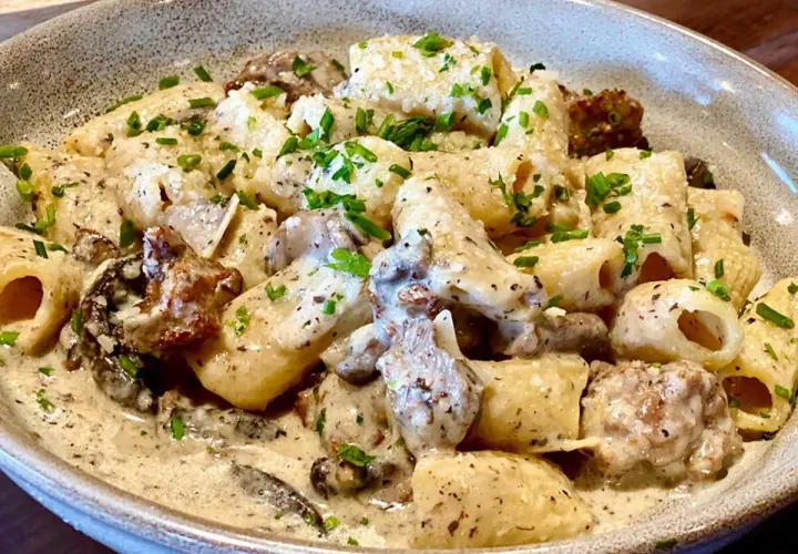 Un plat de pâtes aux champignons, une recette italienne crémeuse et savoureuse, garnie de persil frais.