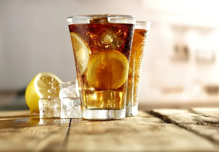 Dwa orzeźwiające long island iced tea z plasterkami cytryny i lodem, gotowe do degustacji.