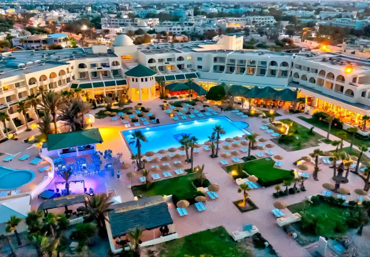 Widok z lotu ptaka na hotel Vincci Dar Midoun. Basen, leżaki, palmy i budynki hotelowe tworzą idealne miejsce na wakacje.