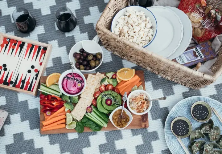 Piknikowy stół z warzywami, dipami i popcornem. Idealna opcja dla weganizmu a wegetarianizmu.