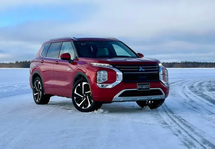 Czerwony Mitsubishi Outlander PHEV na zamarzniętym jeziorze, gotowy na zimowe przygody.