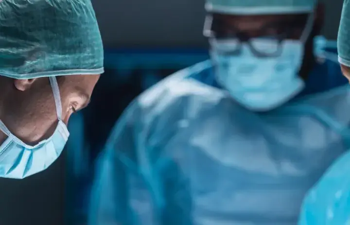 Chirurghi in sala operatoria, concentrati sul loro lavoro. Il loro impegno ha un autoptico significato per la vita dei pazienti.