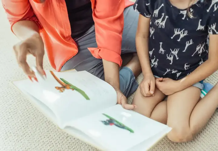 Mama czyta dziecku bajkę o zwierzątkach, ćwicząc zmiękczenia w języku polskim.