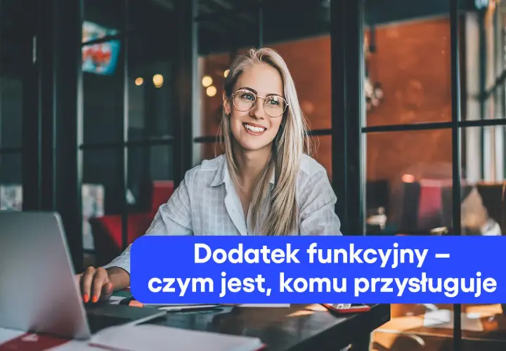 Uśmiechnięta blondynka w okularach pracuje przy laptopie. Na ekranie widnieje napis "Dodatek funkcyjny – czym jest, komu przysługuje".