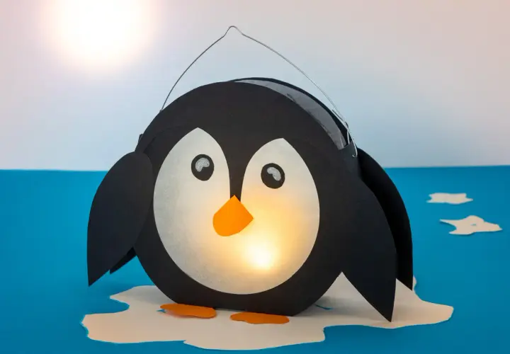 Ein süßer, selbstgebastelter Pinguin als Laterne leuchtet warm. Perfekt zum Basteln für Kinder!