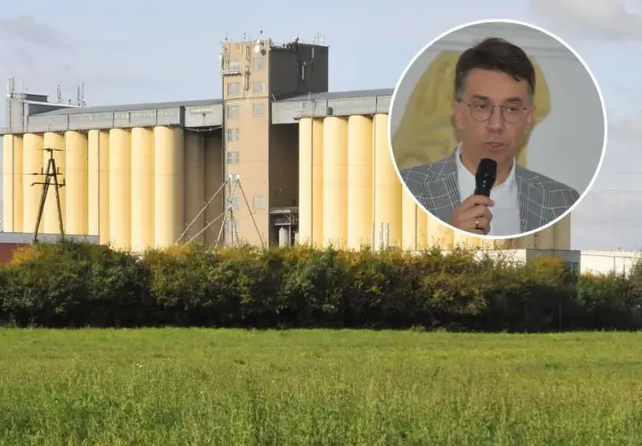 Mężczyzna w okularach przemawia na tle silosów zbożowych. Dyskusja o przyszłej cenie pszenicy 2025.