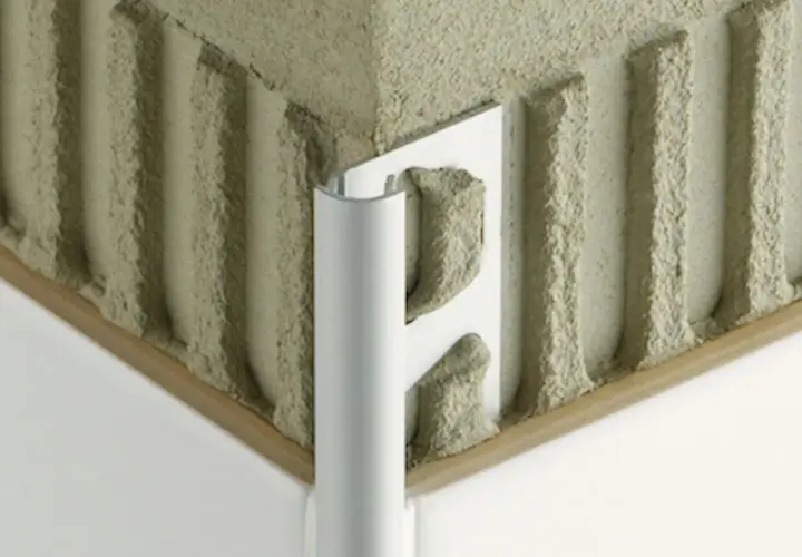 Angolo di un muro con adesivo per piastrelle e un elegante bordino piastrelle in alluminio.
