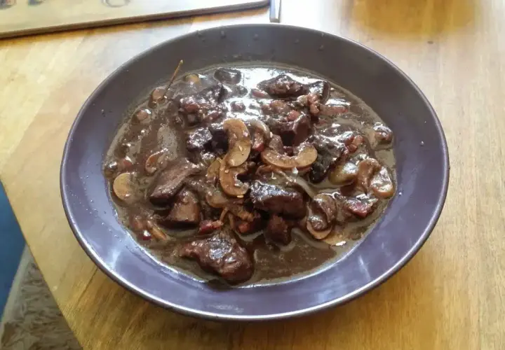 Un plat de bœuf mijoté dans une sauce riche, avec des champignons et des lardons. Un vrai délice pour un bourguignon, parfait avec un bon vin pour bourguignon.