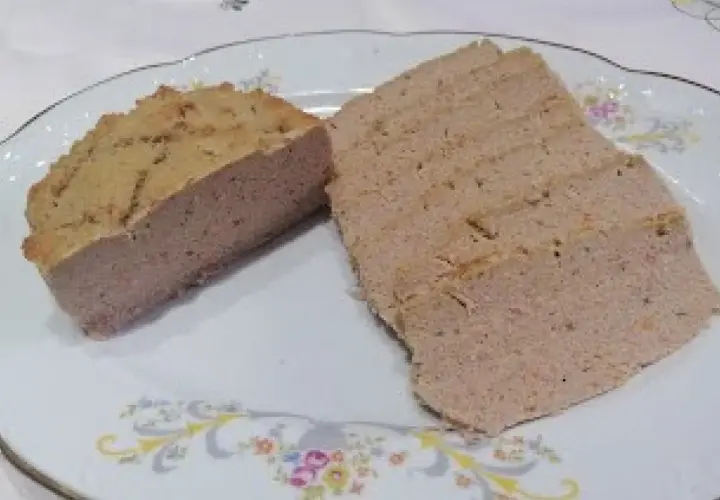 Pokrojony pasztet wieprzowy na talerzu z ozdobnym wzorem.