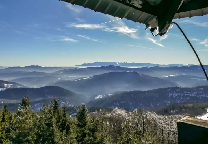 Widok z wieży widokowej na Beskid Wyspowy. W dole lasy i doliny, w oddali pasmo górskie. To najładniejszy szlak na Mogielicę.